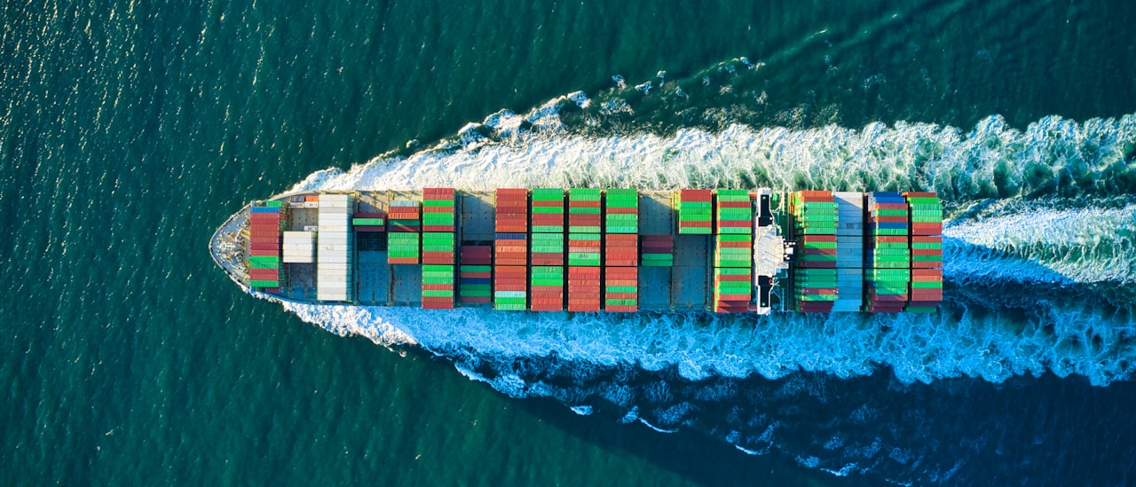 Aerial view of a cargo vessel cutting through open water